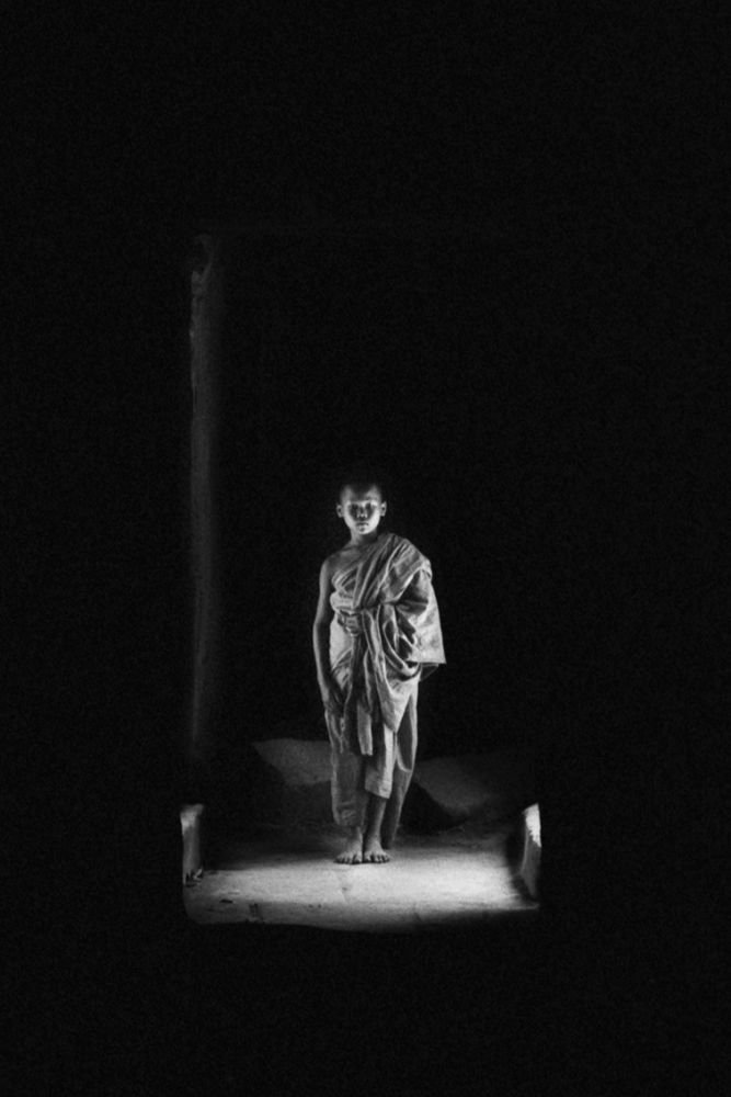 Portrait d’un jeune moine en noir et blanc, ruines de Ta Phrom, au Cambodge