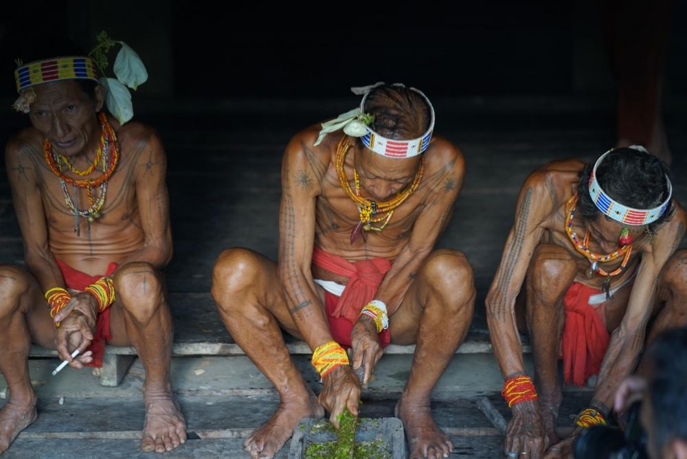 Hommes-fleurs Mentawai préparant des flèches empoisonnées