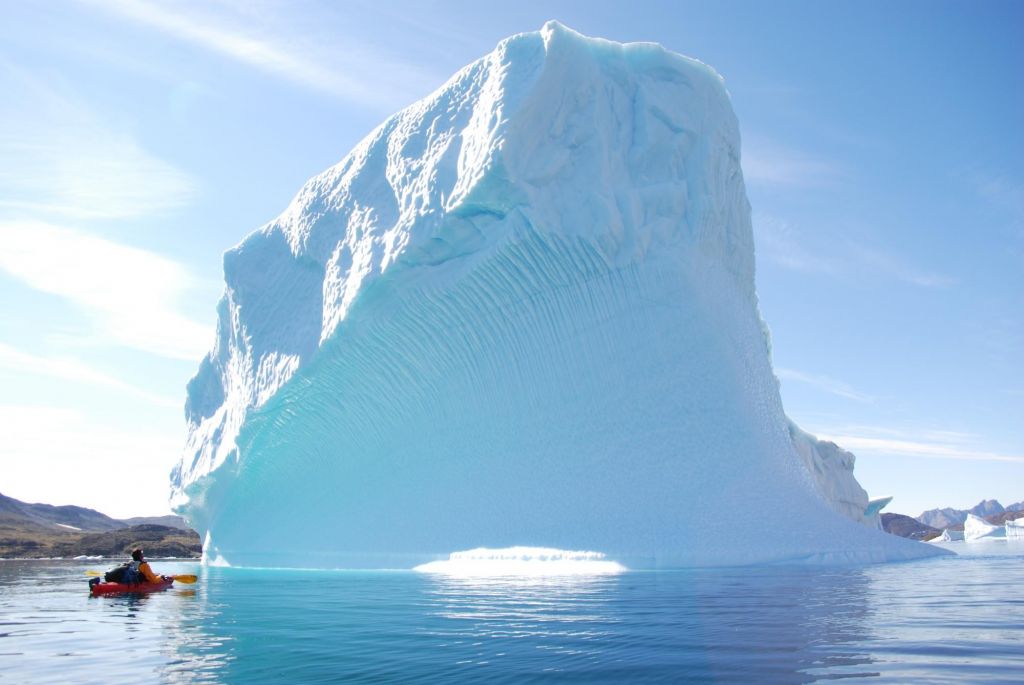 Kayak devant un immense iceberg au Groenland